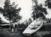 811896 Afbeelding van het te water laten van een boot van de Wilhelminagroep zeeverkenners op De Punt, het terrein van ...